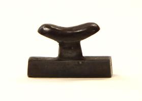 Amulet in form of miniature headrest